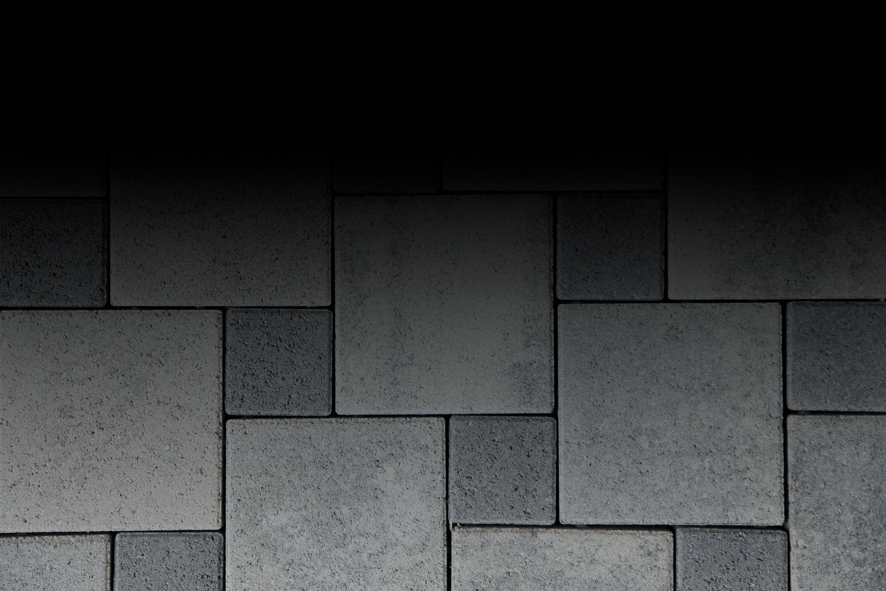 The image depicts a darkened background fading into gray stone tiles arranged in a geometric pattern with varying textures and shades.