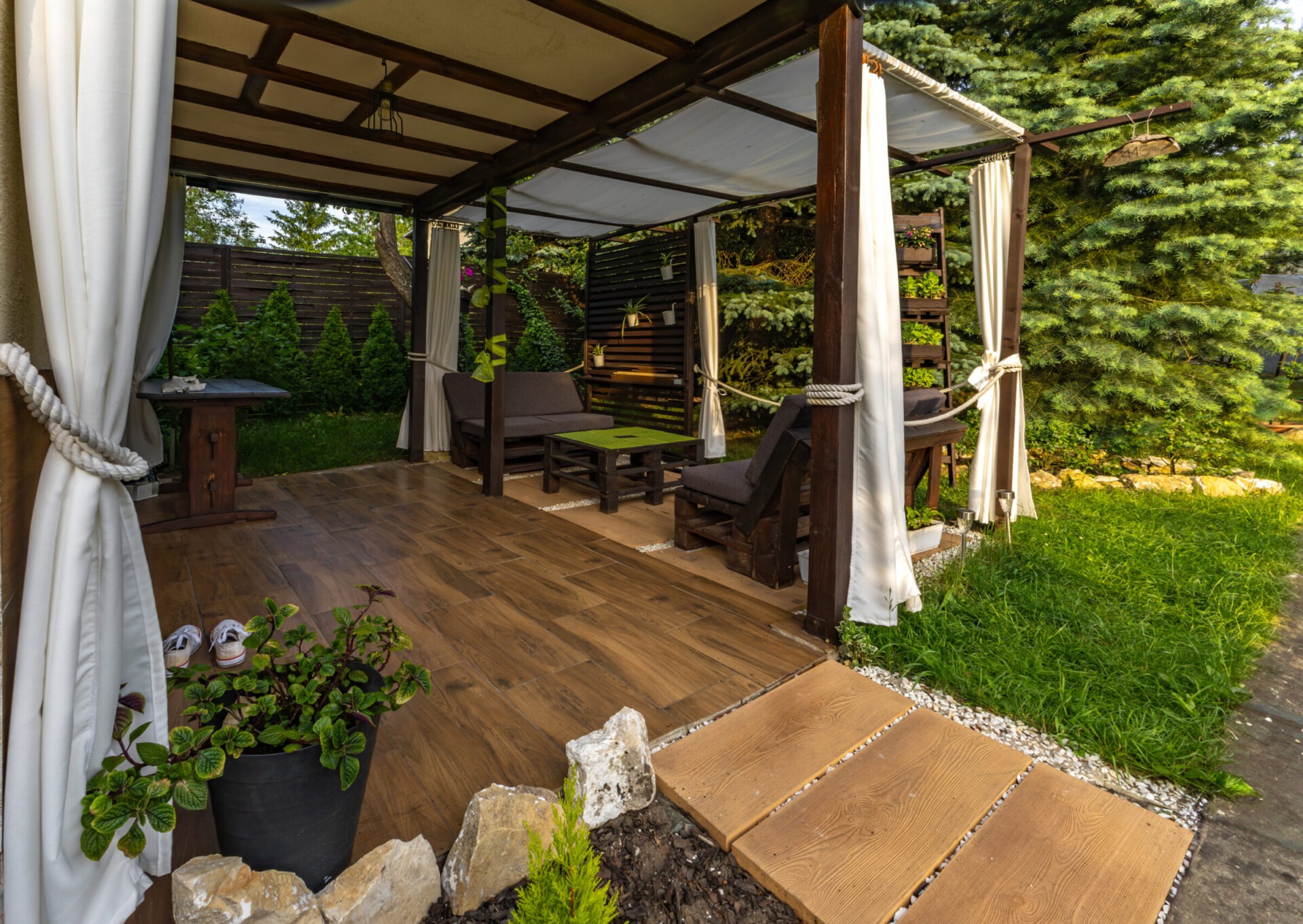 Garden terrace, resting place, garden furniture made of wooden pallets, pergola and flowers